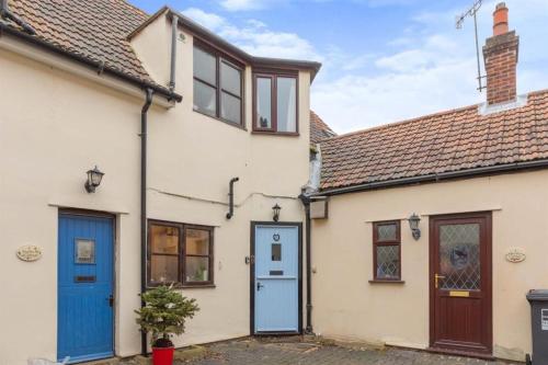 a cottage with a blue door and windows at 5 Stable Cottages , Hartington Road, Cromer.North Norfolk. NR27 0EJ in Cromer