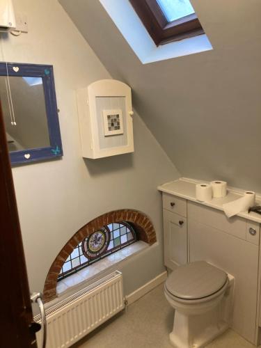 a bathroom with a toilet and a skylight at 5 Stable Cottages , Hartington Road, Cromer.North Norfolk. NR27 0EJ in Cromer