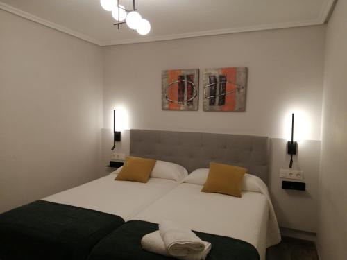 - une chambre avec un grand lit blanc et 2 oreillers dans l'établissement Lugar especial, gran patio, junto al ayuntamiento, à Bilbao