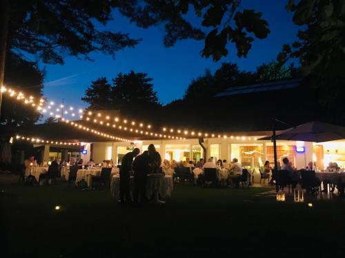 a group of people standing in front of a marquee at night at Golf Hotel La Pinetina in Appiano Gentile