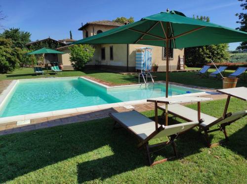 uma piscina com um guarda-sol verde e duas cadeiras e uma mesa e um guarda-sol em Sole Mio em Velletri