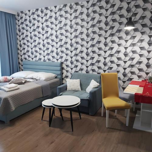 a bedroom with a bed and a couch and a table at Apartament SenGA in Międzyzdroje
