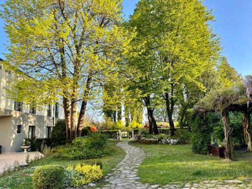 a garden with trees and a stone path at Hotel all'Orso in Biancade