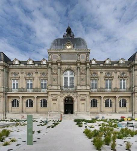 a large building with a dome on top of it at Maison confortable, terrasse et jardin à Amiens in Amiens