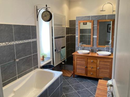 a bathroom with two sinks and a bath tub at Belle maison de famille in Usson-en-Forez