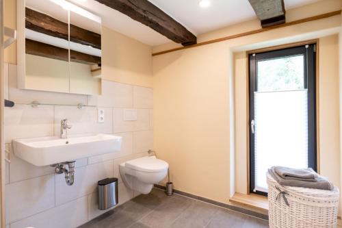 La salle de bains est pourvue d'un lavabo, de toilettes et d'une fenêtre. dans l'établissement Gut Junkernhof, à Calden