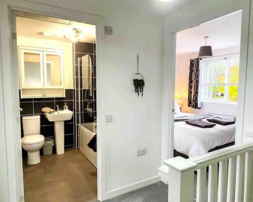 a bathroom with a bed and a toilet and a sink at Loch Leven Getaway - 2 bed house in Kinross