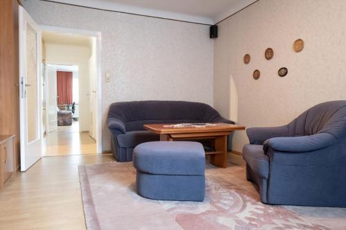 - un salon avec deux chaises bleues et une table dans l'établissement City Smart Home, Hi-End Services, Media Streaming, à Vienne