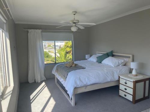 a bedroom with a bed and a large window at Silver Sunsets Self-Catering Apartments in Cape Town