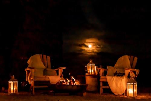 two chairs and a fire pit in the dark at Off the Track Scotland, Luxury Lodge in Crail