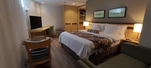 een hotelkamer met een bed en een bureau met een computer bij RARIDADE!!! - Flat de Alto Padrão - Excelente Atendimento - Ótimo Preço - Cama King Size - Limpeza Diária Gratuita in Brasilia