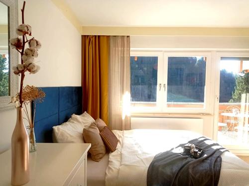 1 dormitorio con cama, mesa y ventana en FeWo Tulipa Vera mit traumhafter Aussicht, en Todtmoos