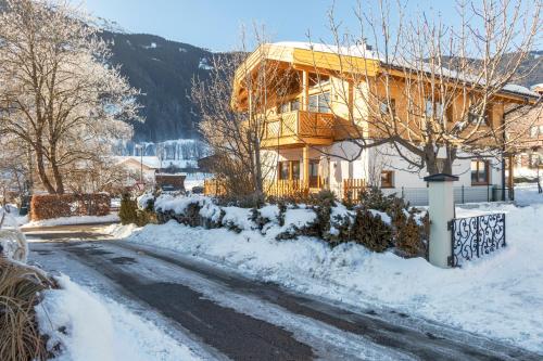 a house on a snow covered road in front of a house at Chalet Mandl Sauna Pool Rollstuhlgängig in Maishofen