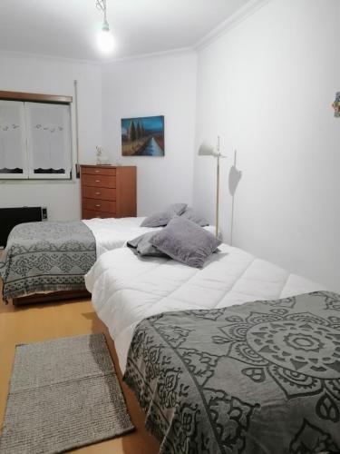 a bedroom with two beds and a dresser at PENICHE - Guest House Casa das Estelas in Peniche
