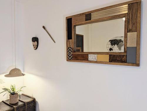 a mirror on a wall next to a lamp at Chambres d'Hôtes La Filature in Saint-Quentin