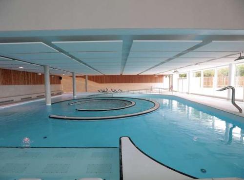 une grande piscine avec de l'eau bleue dans un immeuble dans l'établissement Maison Famille-Confort-Terrasse Jardin-Vue Cathédrale, à Amiens