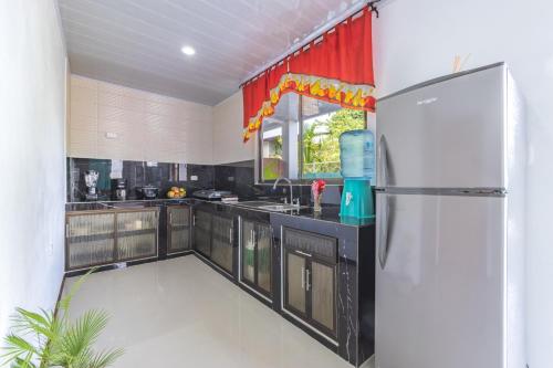 a kitchen with black cabinets and a refrigerator at Villas Mapache del Caribe in Puerto Viejo