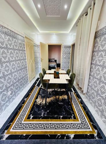 een eetkamer met een tafel en stoelen op een tapijt bij Appartement avec jolie terrasse privée et parking Apartment with nice private terrace and parking in Marrakesh