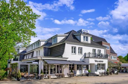 a white building with a black roof at Hotel du Nord, Hamburg-Volksdorf in Hamburg