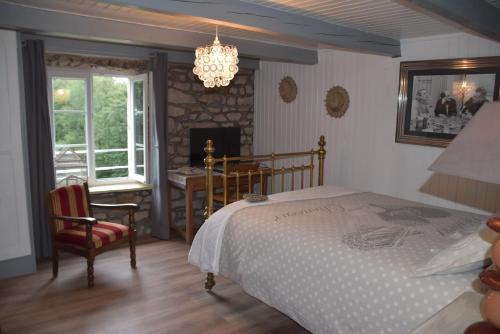 a bedroom with a bed and a table and a fireplace at GITE DU BOIS DES HAUTS LES MILLE ETANGS in La Lanterne-et-les-Armonts