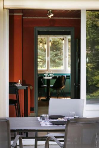 une table et des chaises dans une pièce avec une fenêtre dans l'établissement Do Ré Mi, à Talant