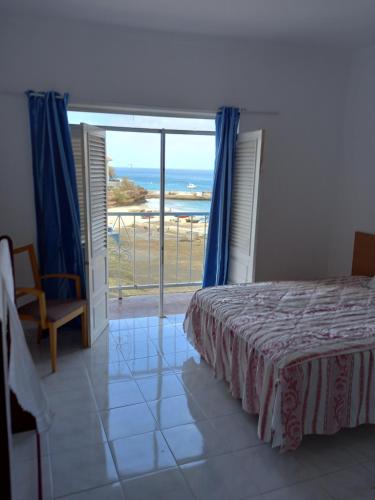 a bedroom with a bed and a view of the ocean at Hotel Sol Marina in Tarrafal