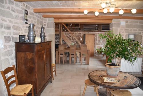 a room with a table and chairs and a brick wall at GITE DU BOIS DES HAUTS LES MILLE ETANGS in La Lanterne-et-les-Armonts