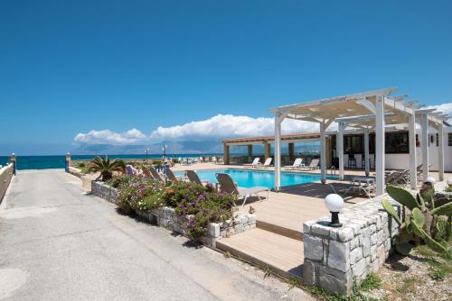 a resort with a swimming pool and the ocean at Captain's Beach Apartments in Kissamos