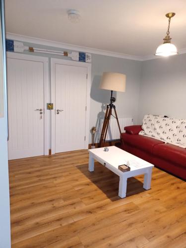 a living room with a red couch and a coffee table at The Boathouse in Cork