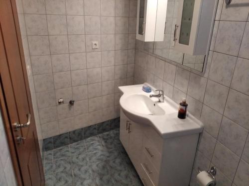 a white bathroom with a sink and a mirror at Villa Kalliopi 