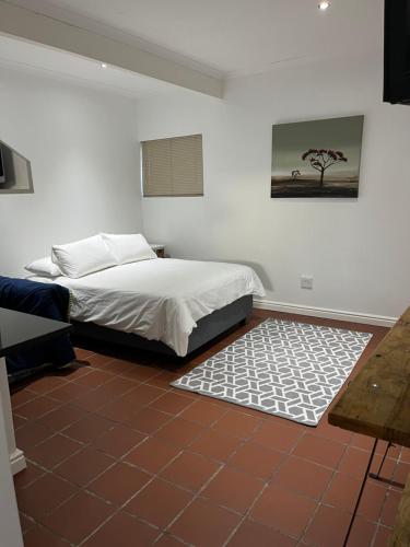 a bedroom with a bed and a rug at Studio 7 on Risa in Port Elizabeth