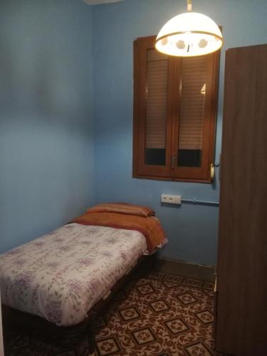 Dormitorio pequeño con cama y luz en Pis Cèntric, en Manresa