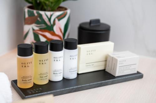 a shelf with four bottles of products on it at Epoch House & The Orange Shop - Adults Only in Nafplio