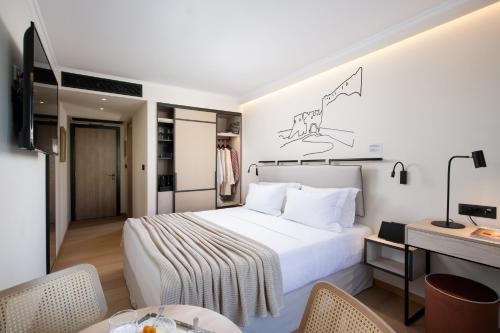 a hotel room with a white bed and a desk at Epoch House & The Orange Shop - Adults Only in Nafplio