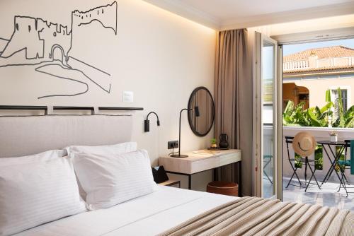 a bedroom with a bed and a desk and a window at Epoch House & The Orange Shop - Adults Only in Nafplio