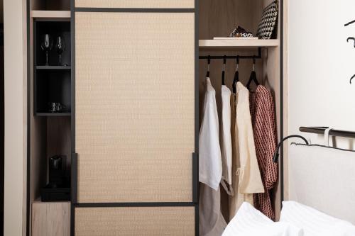 a closet with a sliding door with clothes at Epoch House & The Orange Shop - Adults Only in Nafplio