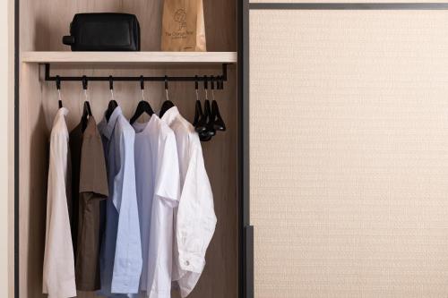 a closet with a rack of clothes and a notebook at Epoch House & The Orange Shop - Adults Only in Nafplio