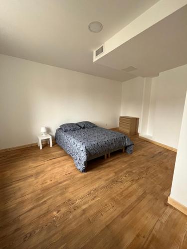 a bedroom with a bed and a wooden floor at Superbe maison de ville, rénovée à 15 min de Lyon in Saint-Symphorien-dʼOzon