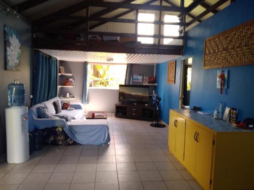 a living room with blue walls and yellow cabinets at VILLA DE LA BAIE RAIATEA - Bord de mer in Uturoa