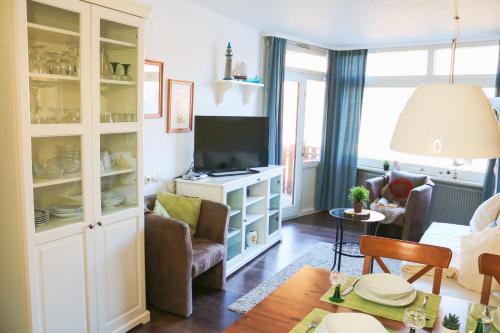 a living room with a couch and a tv at Apartment Caroline - Gemütliche Ferienwohnung mit Pool, Sauna und Hochschwarzwaldcard in Schluchsee