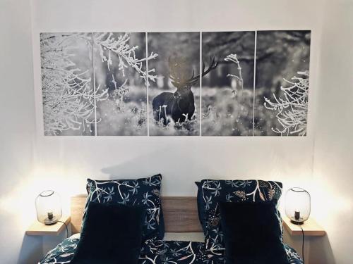 uma imagem a preto e branco de um alce pendurado acima de uma cama em Superbe appartement centre ville proche des pistes em Morez