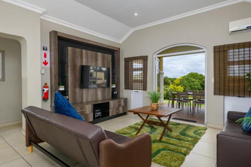 a living room with a couch and a table at Villa Caylee Caribbean Estates - Ultra-Luxurious - Rimas Interiors Designs - Private Beachfront Escape - Premium serviced for 8 Guests in Port Edward