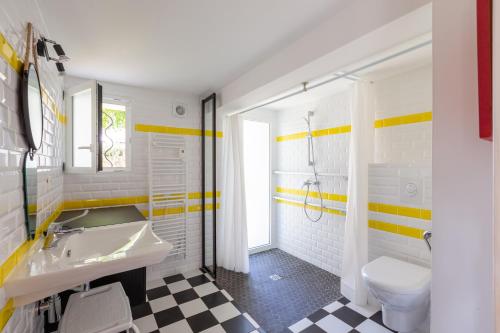 une salle de bain avec un lavabo et des toilettes dans l'établissement Maison Royan Foncillon-Chay classée PMR, à Royan