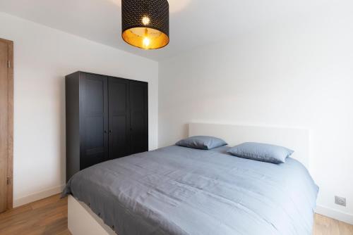 a bedroom with a large bed with a black cabinet at LE 23 in Jarny