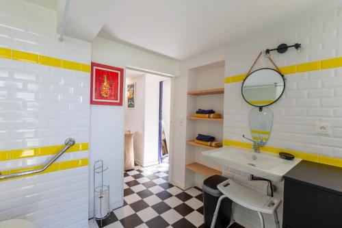 une salle de bain avec un lavabo et un miroir dans l'établissement Maison Royan Foncillon-Chay classée PMR, à Royan