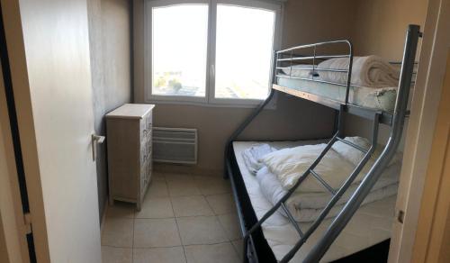 een kamer met 2 stapelbedden en een raam bij Cap Eden in Saint-Jean-de-Monts
