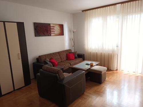 ein Wohnzimmer mit einem Sofa und einem Tisch in der Unterkunft Apartman Kajzerica in Zagreb