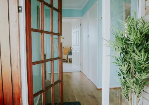DonVera - Two Bedroom Bungalow with Sea Views في Overcombe: باب يؤدي إلى مدخل مع نباتات الفخار