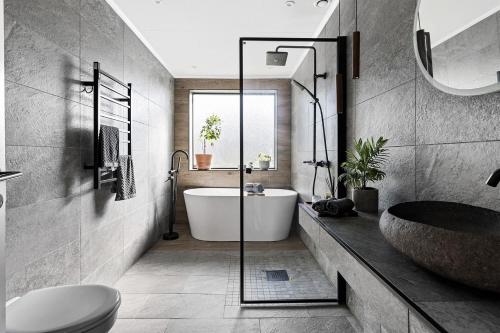 a bathroom with a tub and a sink at Härlig villa i Sävedalen 10 min till Göteborg in Gothenburg