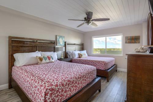 a bedroom with two beds and a ceiling fan at 707 Sandcastle One in Clearwater Beach
